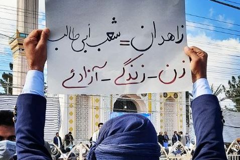 A protester in Zahedan holding a placard that reads the main motto of the protests: women, life, liberty