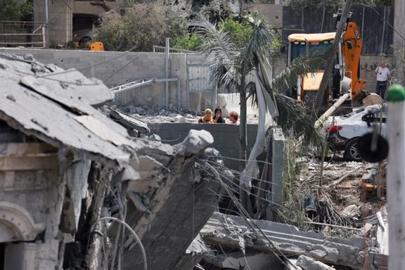 Women look at a damaged building and debris after missiles fired from Iran impacted a residential building, in Tamra, northern Israel June 15, 2025.
