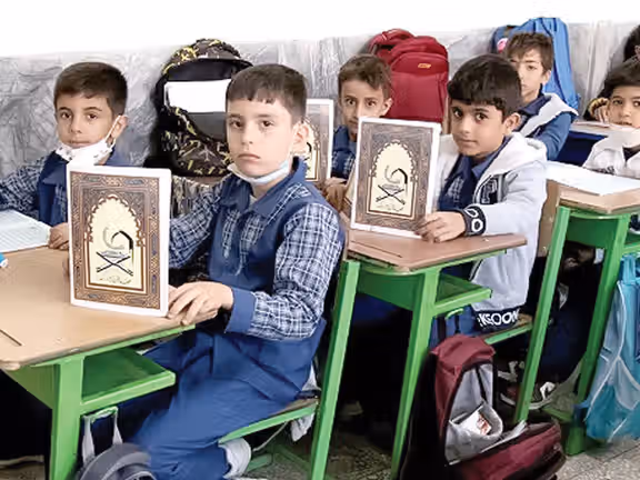 Young school children in Iran with abridged copies of the Qur'an, undated file photo