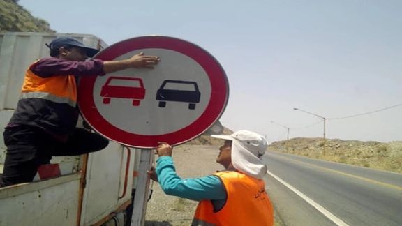 Workers installing road signs in Iran. Undated