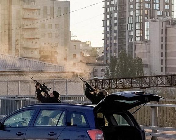 Police officers shoot at a drone during a Russian drone strike, which local authorities consider to be Iranian-made Shahed-136 unmanned aerial vehicles (UAVs), amid Russia's attack on Ukraine, in Kyiv, Ukraine October 17, 2022.