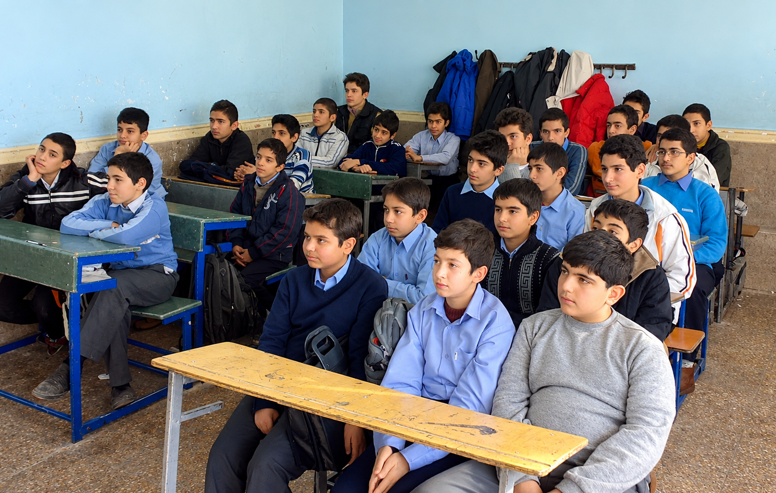 Students attend a classroom lesson at a school in Iran, where some families are increasingly exploring international online education as an alternative to the domestic curriculum.