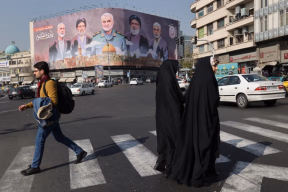 Iranians walk next to a billboard with a picture of late Hamas leader Ismail Haniyeh, late senior Iranian military commander General Qassem Soleimani, late Lebanon's Hezbollah leader Sayyed Hassan Nasrallah and late Hamas leader Yahya Al-Sinwar on a street in Tehran, Iran, January 16, 2025.