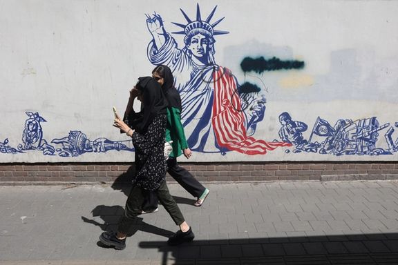 People walk past an anti-US mural on a street in Tehran, Iran, April 19, 2025.