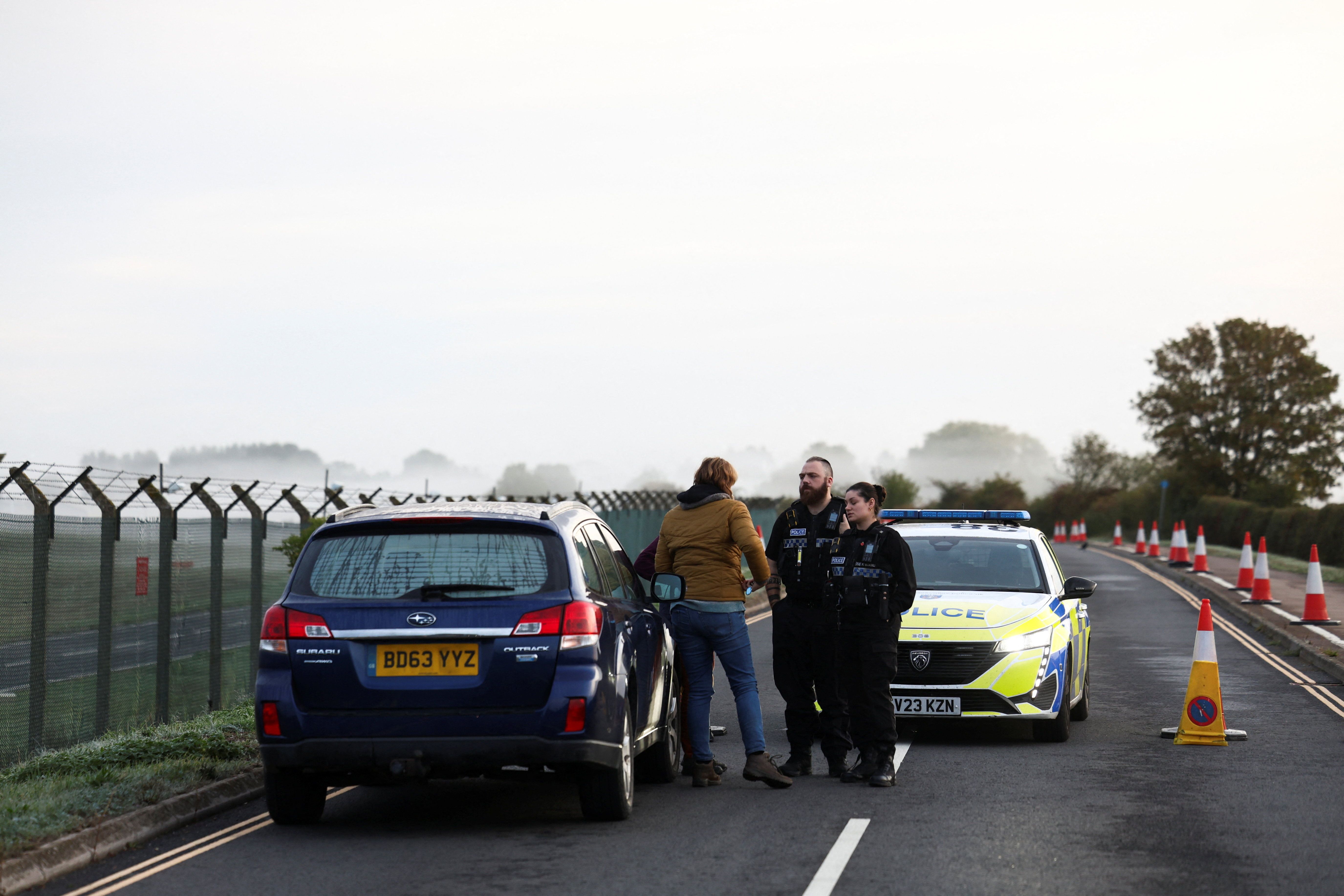 Police officers work on a road outside the perimeter of the RAF Fairford airbase, after police declared a major incident at the base after several men were arrested on suspicion of offences under the Explosives Act, in Fairford, Gloucestershire, Britain, September 28, 2026.