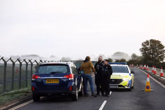 Police officers work on a road outside the perimeter of the RAF Fairford airbase, after police declared a major incident at the base after several men were arrested on suspicion of offences under the Explosives Act, in Fairford, Gloucestershire, Britain, September 28, 2026.