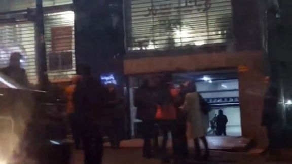 People outside the offices of Fardaye Eghtesad magazine following a raid by security agents, Tehran, February 2024