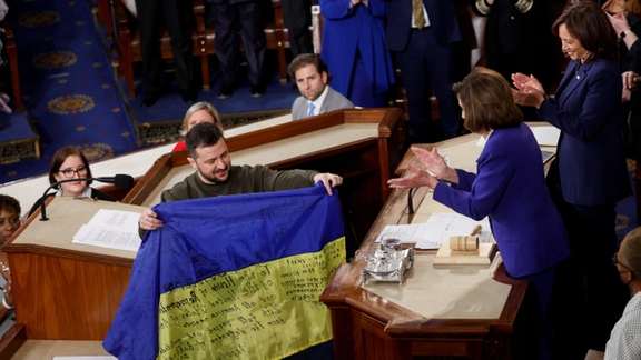 Volodymyr Zelanskyy presenting a Ukrainian flag to Nancy Pelosi at US Congress on December 21, 2022