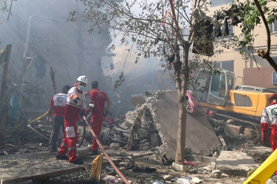 Rescuers work at the site of a damaged building, in the aftermath of Israeli strikes, in Tehran, Iran, June 13, 2025. 