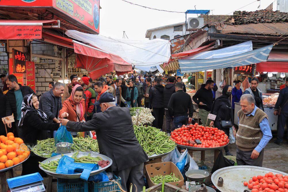 People shop at a crowded produce market in Rasht, northern Iran.