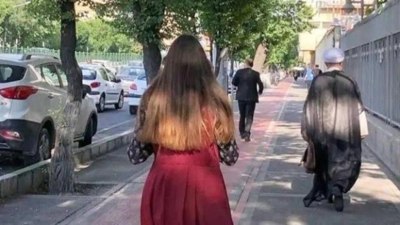 A woman without hijab walking in a Tehran street