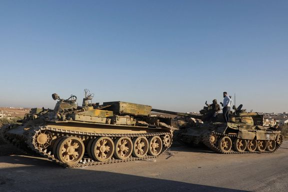 Men stand on a damaged military vehicle in the city of Maarat al-Numan, in Idlib province, after rebel fighters captured the city, Syria December 1, 2024.