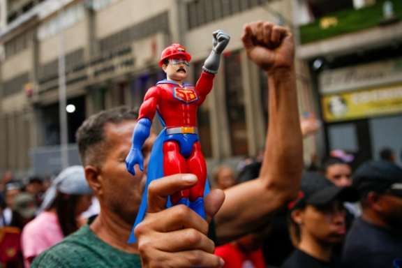 A person holds a doll in the likeness of Venezuela's President Nicolas Maduro dressed in a superhero costume, as people attend a march calling for his release, after he and his wife Cilia Flores were captured following US strikes on Venezuela, in Caracas, Venezuela January 4, 2026.