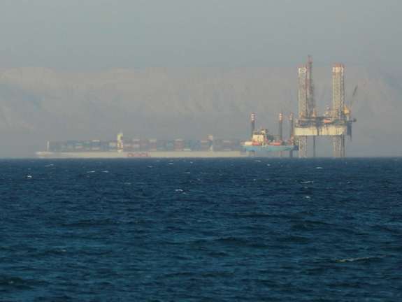 A container ship crosses an oil platform at the Gulf of Suez towards the Red Sea before entering the Suez Canal, outside of Cairo, Egypt September 1, 2020.
