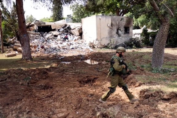 An Israeli soldier walks past a building damaged in Kibbutz Kfar Aza, in southern Israel, October 10.